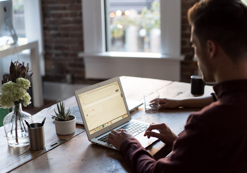 A person working at a laptop beside a window