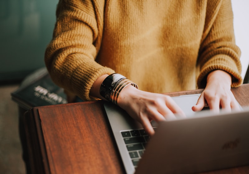 A person reading on a laptop at a table